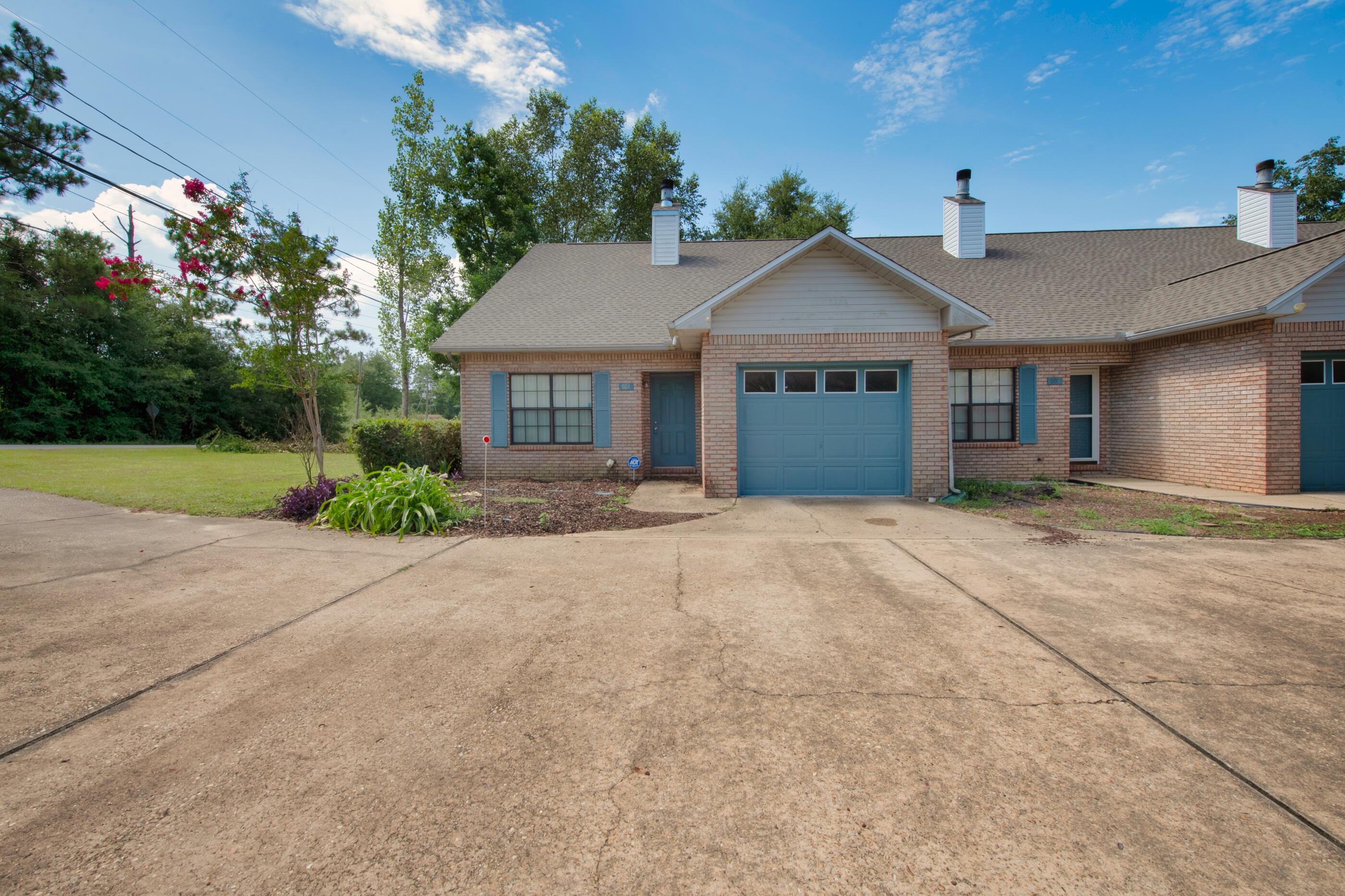 701 Valley Road, Unit 1 Crestview, FL 32539 - Photo 2 of 20 a front view of a house with a yard and garage