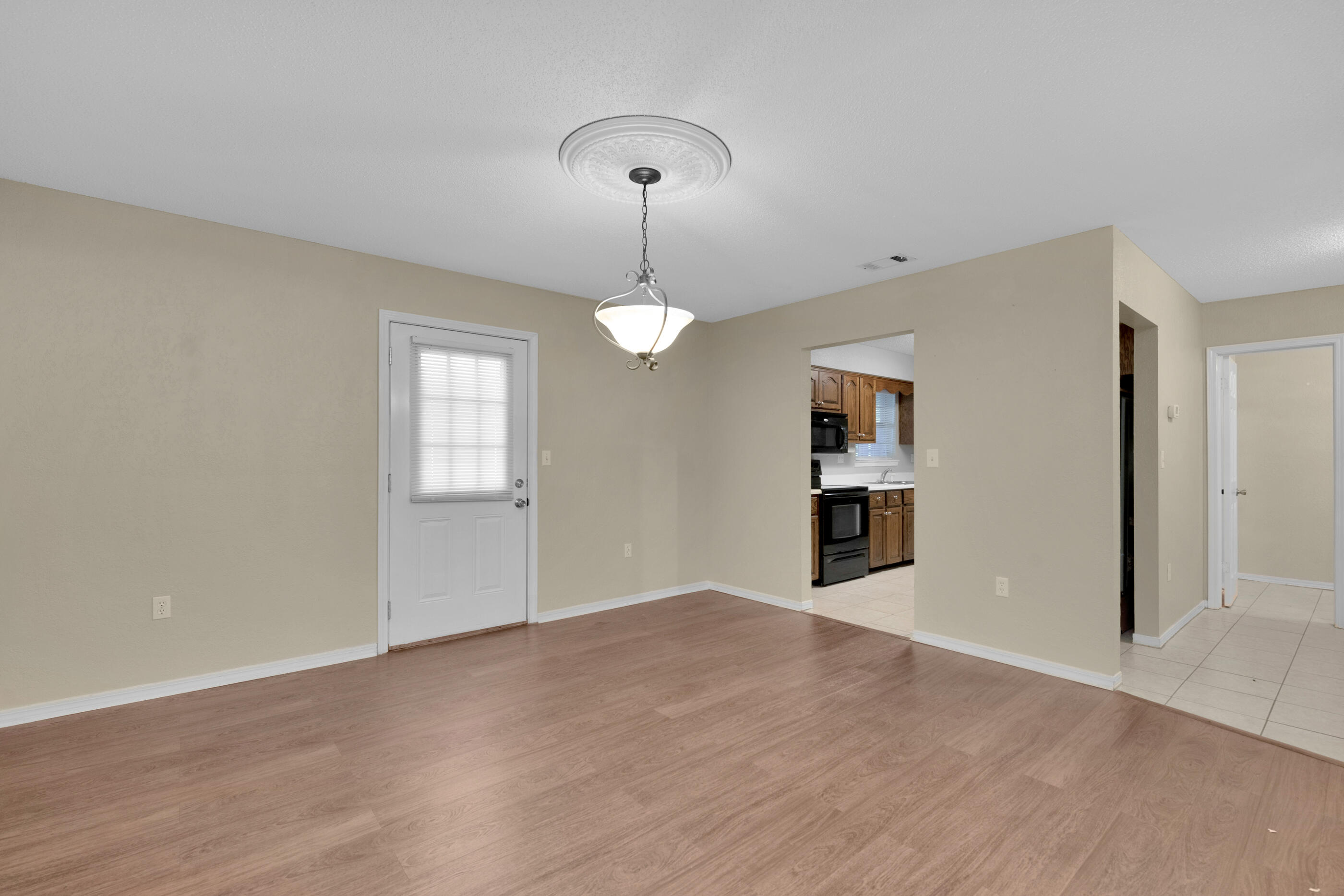 701 Valley Road, Unit 1 Crestview, FL 32539 - Photo 7 of 20 wooden floor in an empty room with a window