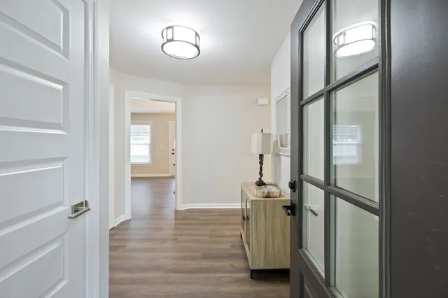 a view of a hallway with wooden floor and closet
