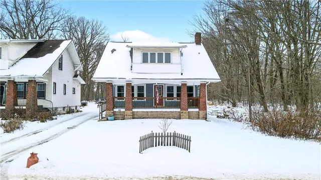 a front view of a house with a yard covered with snow in the yard