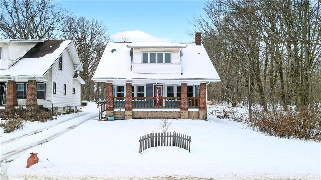 a front view of a house with a yard covered with snow in the yard