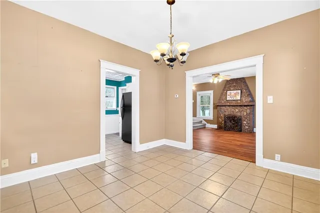 a view of a hallway with wooden floor and a chandelier