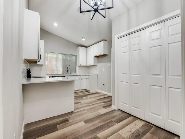a kitchen with kitchen island white cabinets and stainless steel appliances