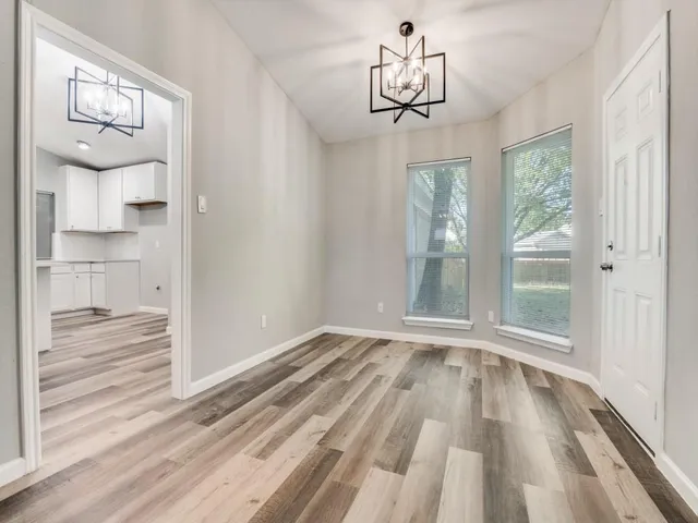 a view of empty room with wooden floor and window