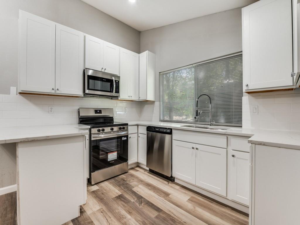 4523 Hamblen Drive Dallas, TX 75232 - Photo 9 of 25 a kitchen with granite countertop white cabinets a sink and stainless steel appliances