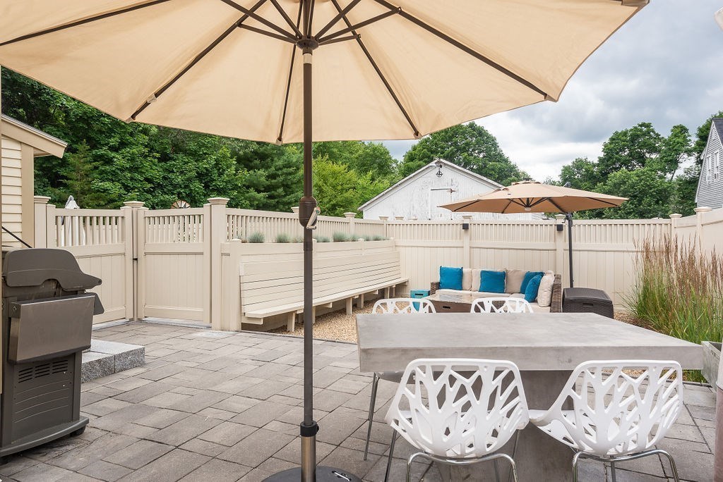 1844 Main Street, Unit 1844 Concord, MA 01742 - Photo 40 of 42 a view of table and chairs under an umbrella