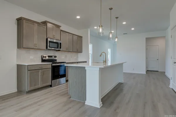a kitchen with stainless steel appliances granite countertop a sink a stove and a wooden floors
