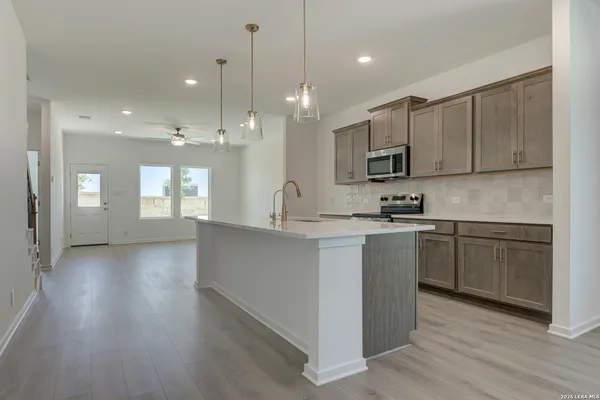 an empty room with wooden floor and a ceiling fan
