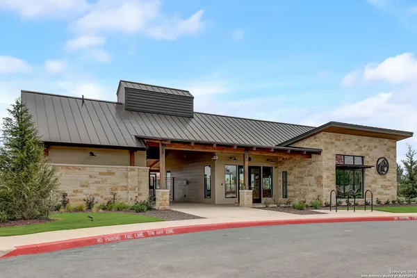 a dining room with wooden floor a chandelier a wooden table and chairs