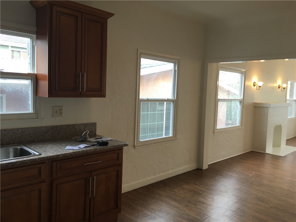 1043 Stanley Avenue Long Beach, CA 90804 - Photo 11 of 16 a kitchen with granite countertop a sink wooden cabinets and a window