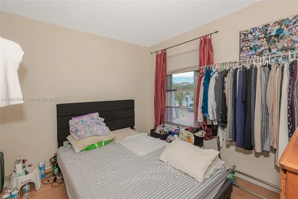a bedroom with a bed closet and a large mirror