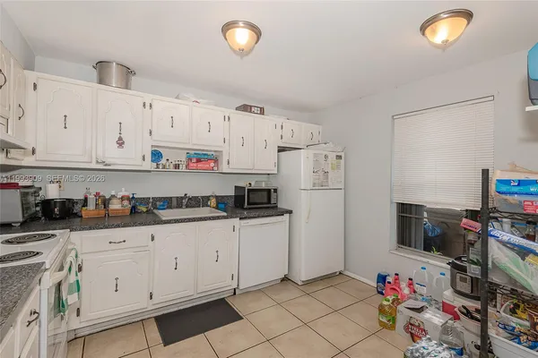 a kitchen with white cabinets and white appliances