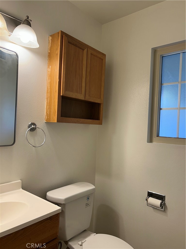 25915 Warwick Road Menifee, CA 92586 - Photo 21 of 34 a bathroom with a toilet a sink and mirror