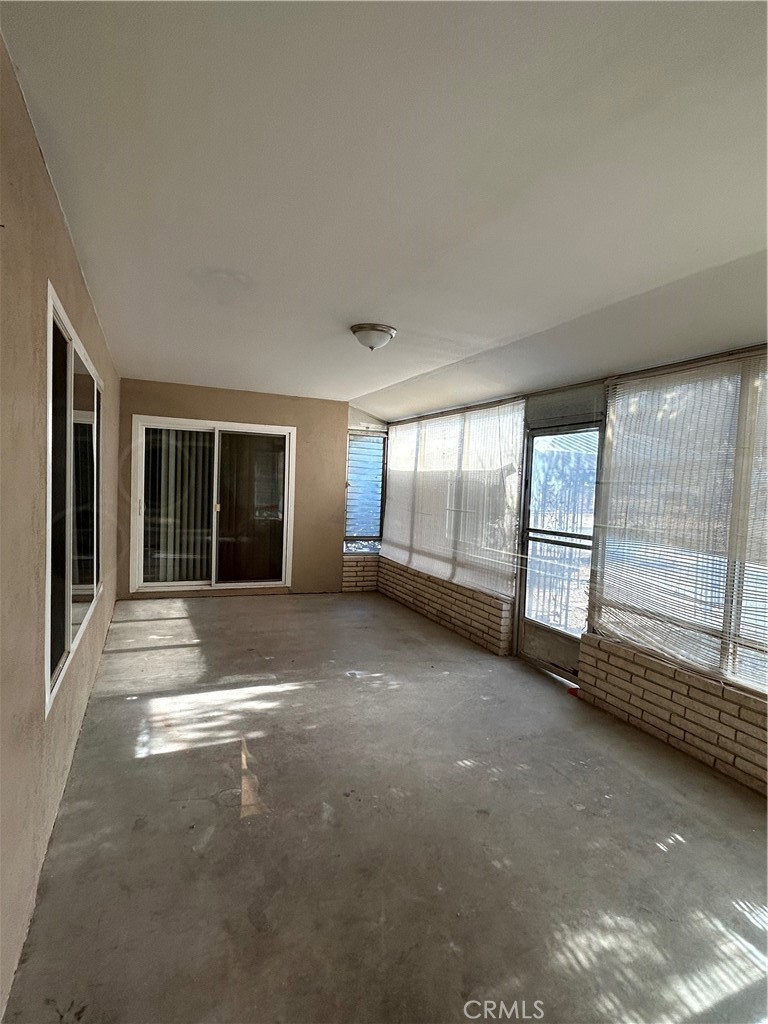 25915 Warwick Road Menifee, CA 92586 - Photo 23 of 34 a view of an empty room with a fireplace and large windows