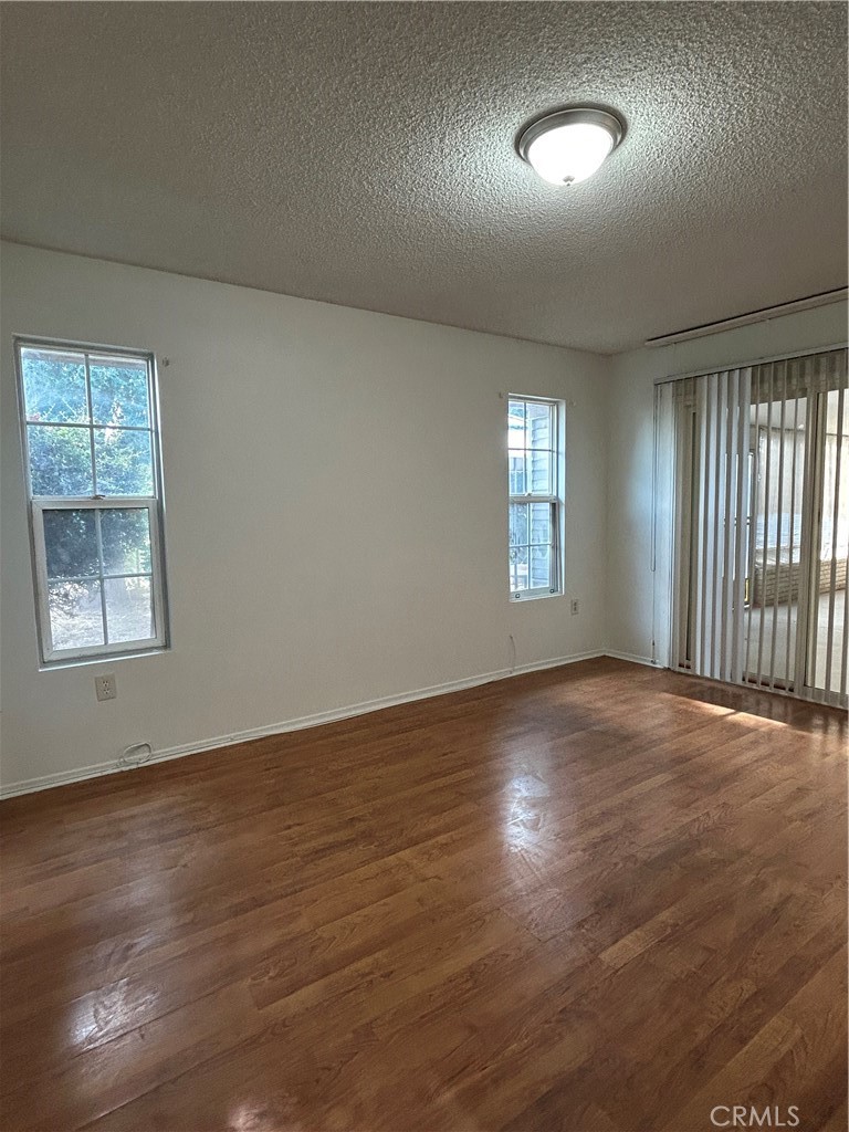 25915 Warwick Road Menifee, CA 92586 - Photo 25 of 34 an empty room with wooden floor and windows