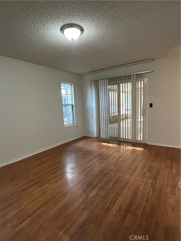25915 Warwick Road Menifee, CA 92586 - Photo 26 of 34 an empty room with wooden floor and windows