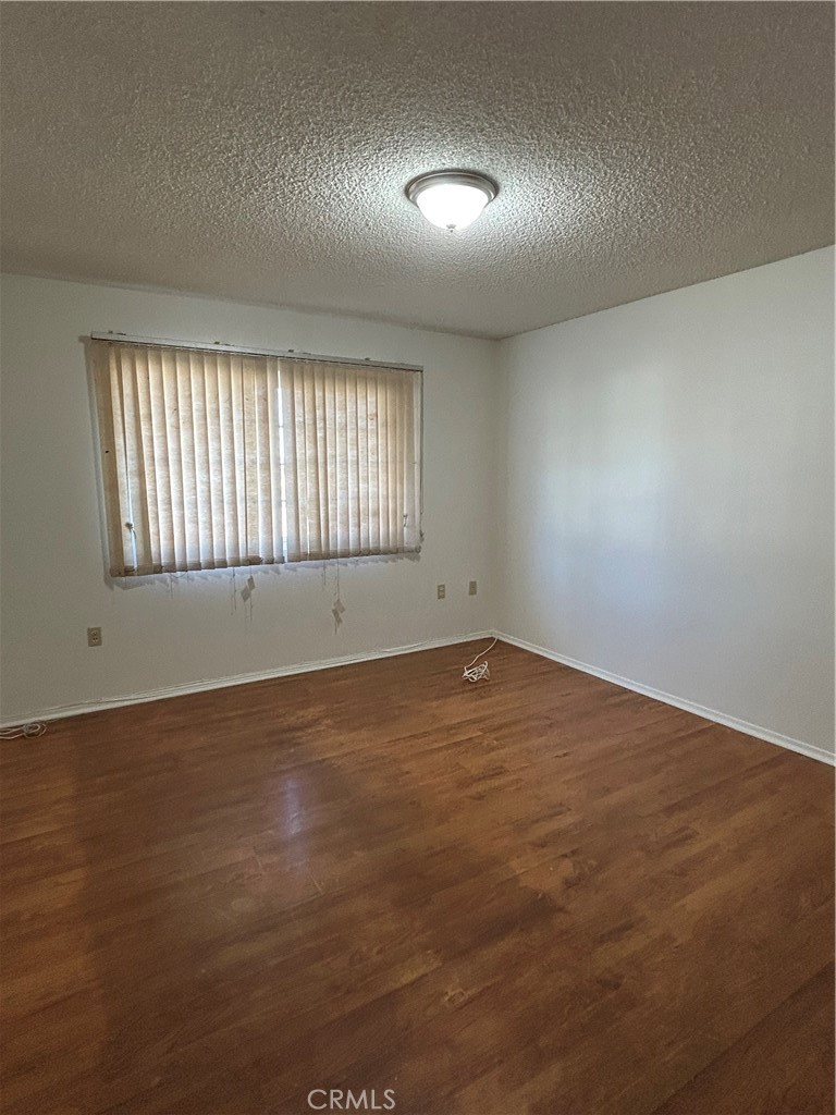 25915 Warwick Road Menifee, CA 92586 - Photo 31 of 34 an empty room with wooden floor and windows