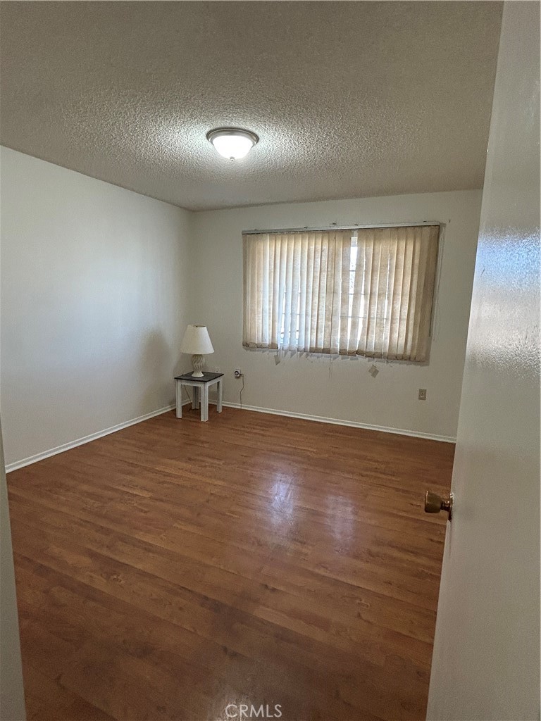 25915 Warwick Road Menifee, CA 92586 - Photo 33 of 34 an empty room with wooden floor and windows