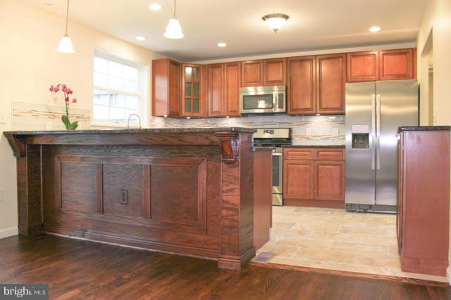 8538 Lucerne Road Randallstown, MD 21133 - Photo 1 of 16 a kitchen with stainless steel appliances granite countertop a stove a sink and a microwave