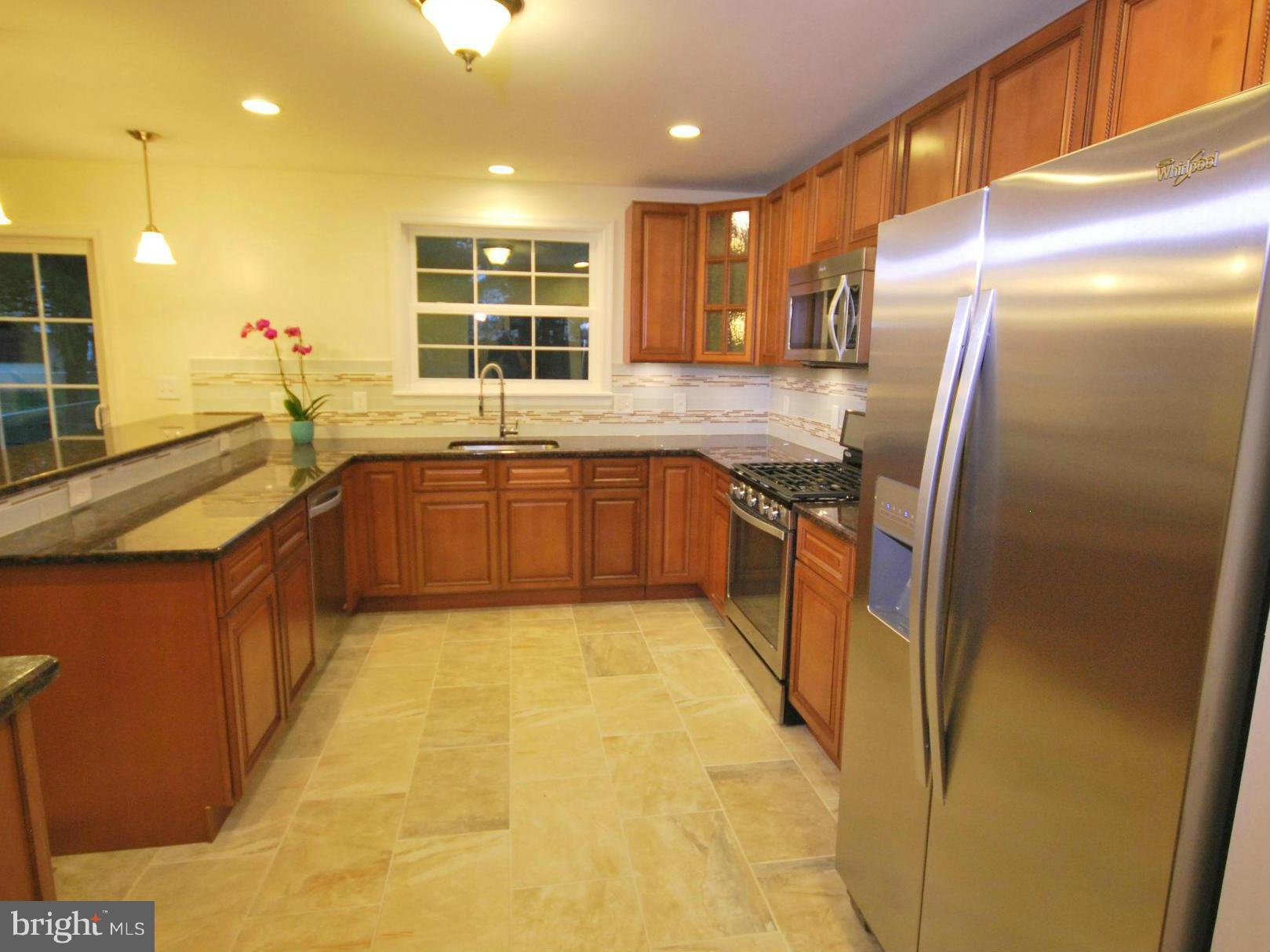 8538 Lucerne Road Randallstown, MD 21133 - Photo 3 of 16 a large kitchen with stainless steel appliances granite countertop a sink and a refrigerator