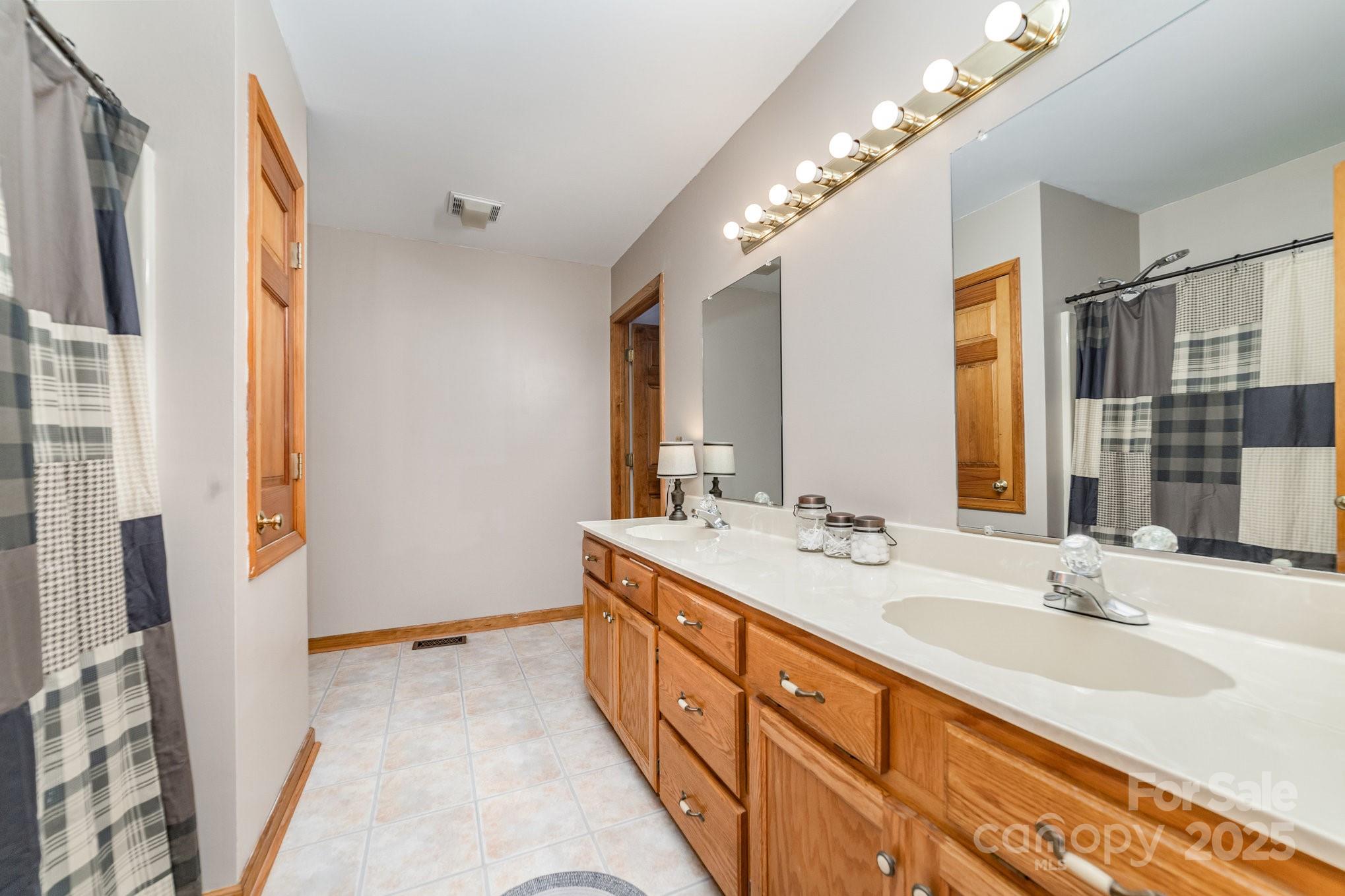2595 Shamrock Road Harrisburg, NC 28075 - Photo 14 of 27 a spacious bathroom with double vanity and a mirror