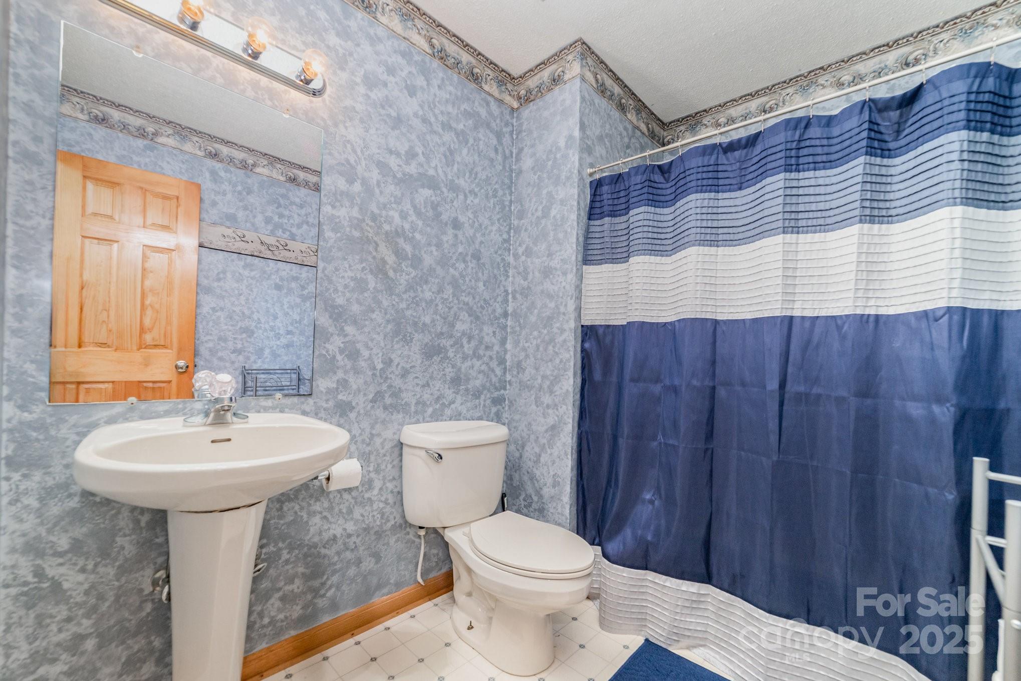 2595 Shamrock Road Harrisburg, NC 28075 - Photo 19 of 27 a bathroom with a sink toilet and shower