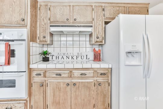 231 South Locust Street Ridgecrest, CA 93555 - Photo 4 of 35 a kitchen with cabinets and a refrigerator