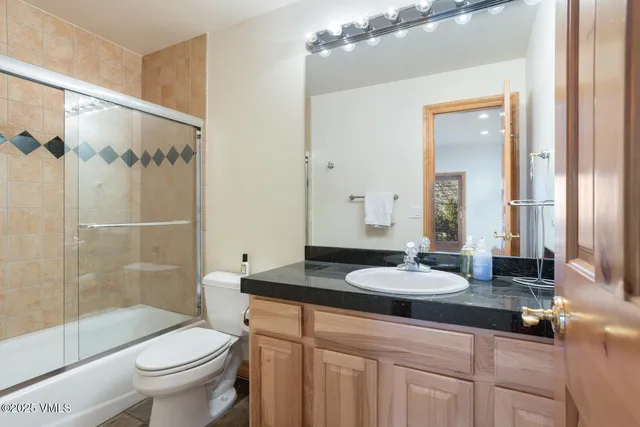 a bathroom with a granite countertop sink toilet and shower