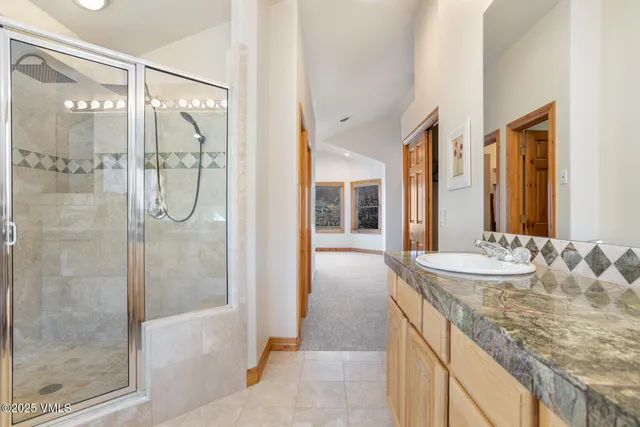 a bathroom with a granite countertop shower mirror and a sink
