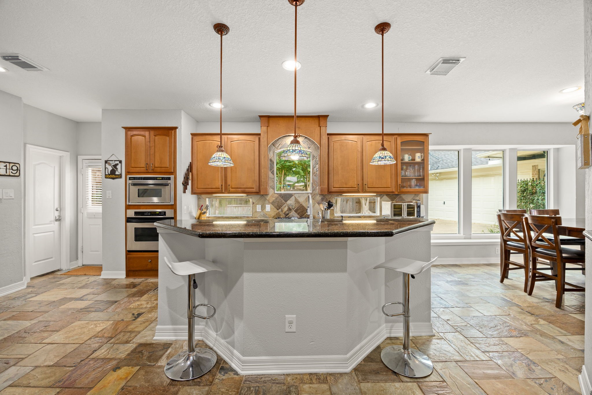 22610 Shallow Spring Court Katy, TX 77494 - Photo 3 of 45 a kitchen with kitchen island granite countertop a dining table chairs and white cabinets