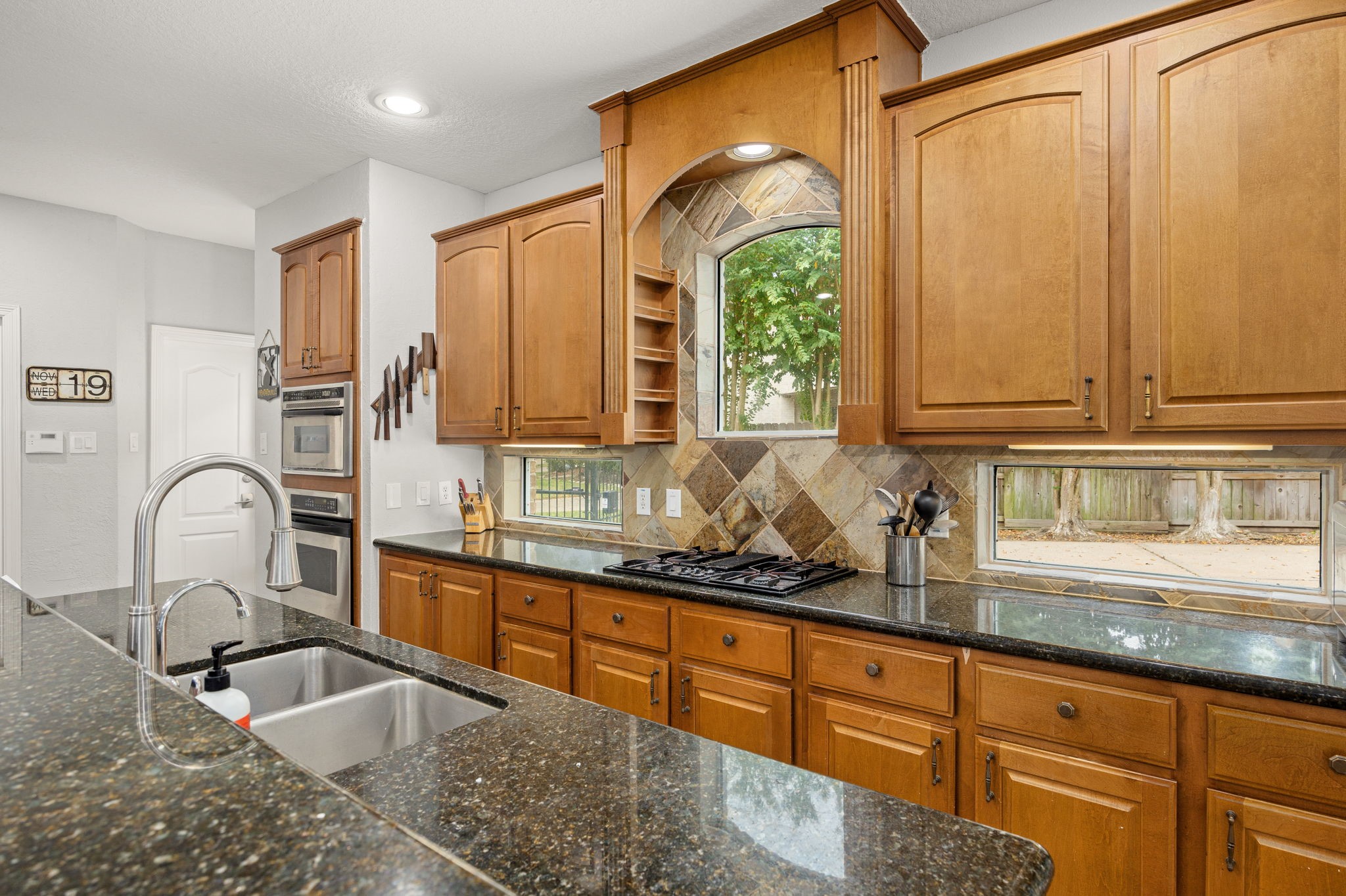 22610 Shallow Spring Court Katy, TX 77494 - Photo 4 of 45 a kitchen with granite countertop a sink a window and stainless steel appliances
