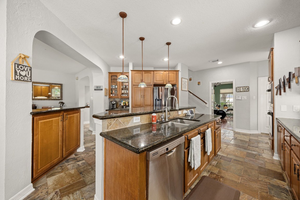 22610 Shallow Spring Court Katy, TX 77494 - Photo 8 of 45 a kitchen with stainless steel appliances granite countertop a sink a counter top space a large cabinets and a chandelier