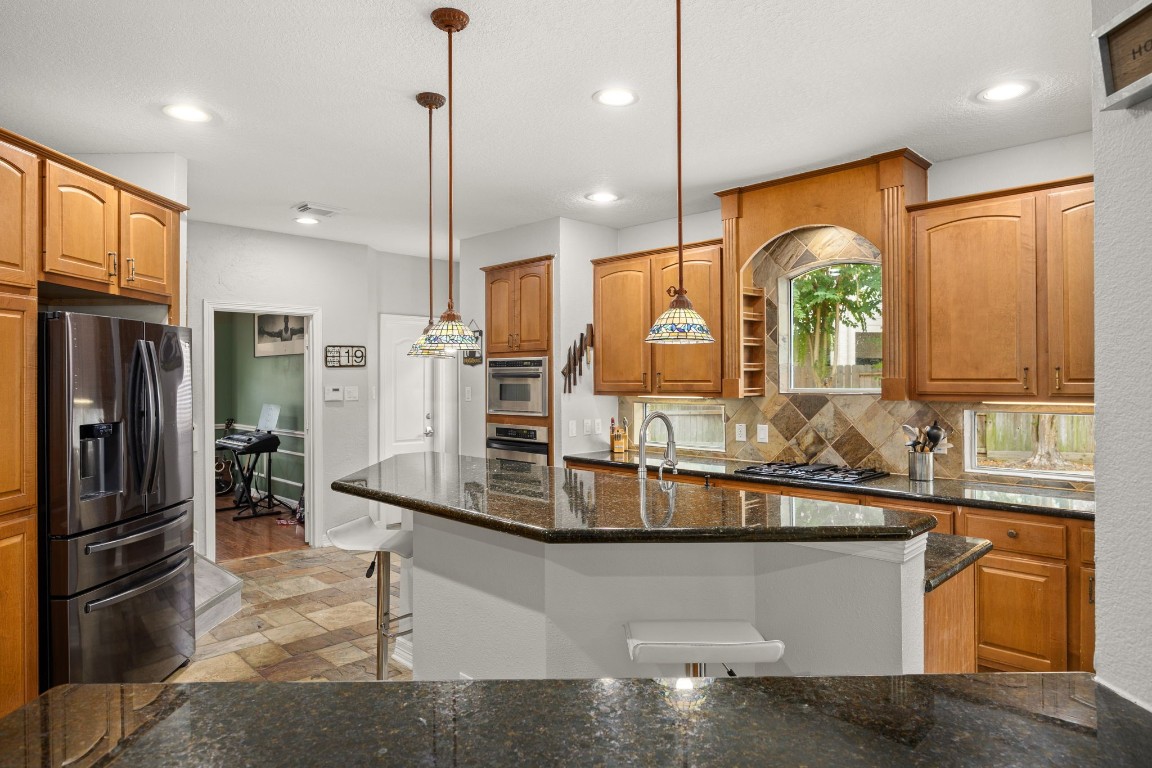 22610 Shallow Spring Court Katy, TX 77494 - Photo 9 of 45 a kitchen with stainless steel appliances granite countertop a sink and a refrigerator