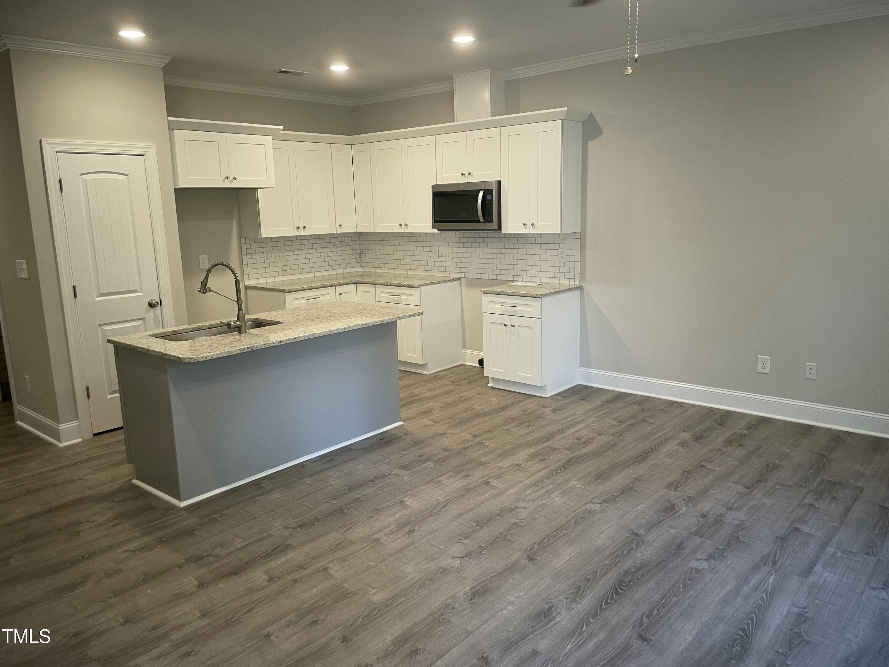 5502 Batoul Lane Raleigh, NC 27606 - Photo 7 of 35 a kitchen with stainless steel appliances granite countertop a sink stove and microwave