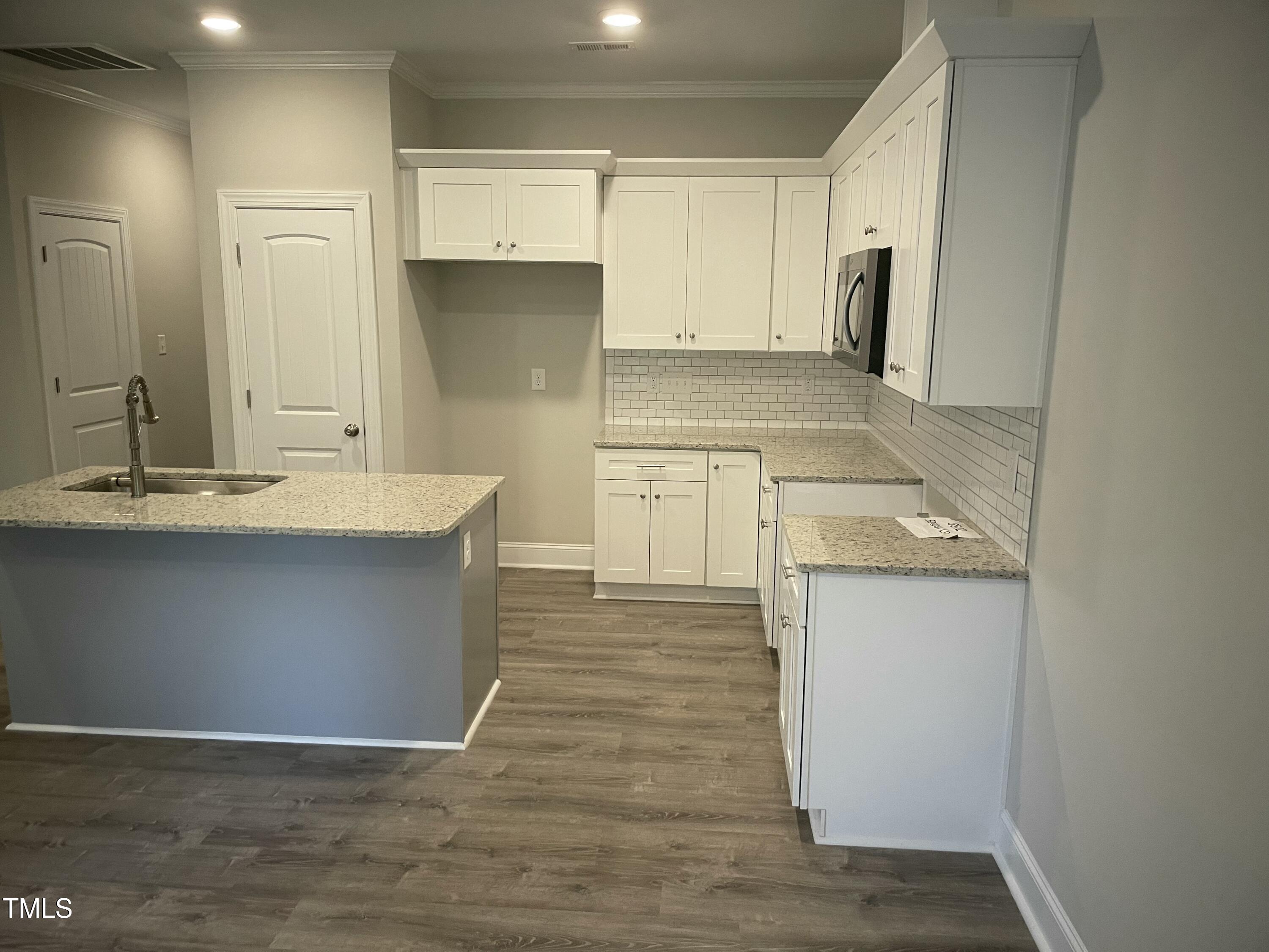 5502 Batoul Lane Raleigh, NC 27606 - Photo 9 of 35 a kitchen with a sink cabinets and wooden floor