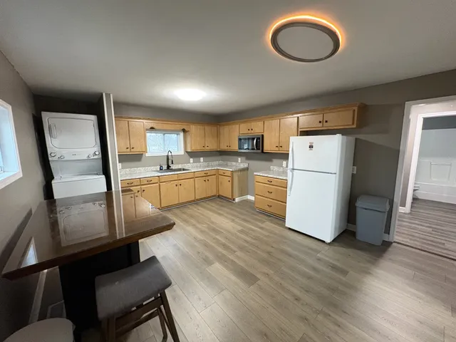 a kitchen with refrigerator cabinets and wooden floor
