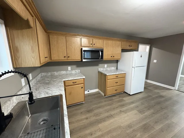 a kitchen with stainless steel appliances granite countertop a refrigerator a stove top oven a sink and dishwasher