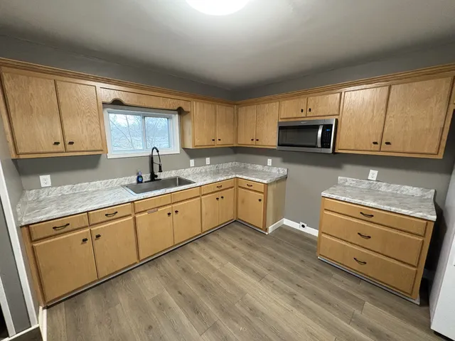 a kitchen with granite countertop white cabinets sink and stainless steel appliances