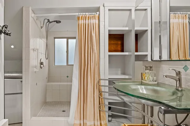 a bathroom with a sink a toilet and a shower curtain