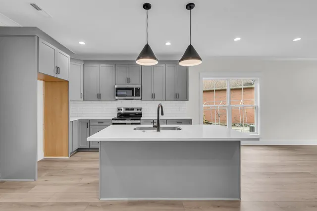 a view of kitchen with granite countertop cabinets a sink a window and stainless steel appliances