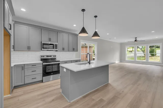 a kitchen with kitchen island a sink stainless steel appliances and window