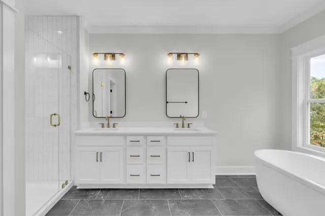 a spacious bathroom with double vanity a mirror a bathtub and a shower