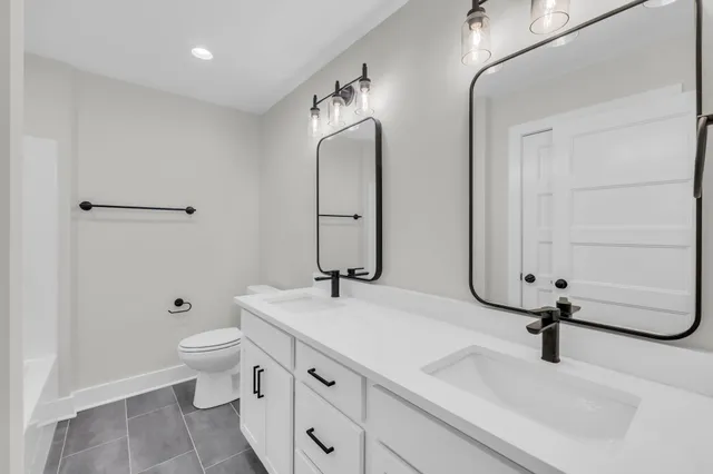 a bathroom with a sink and mirror with toilet