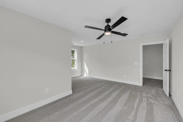 a view of a big room with wooden floor a ceiling fan and closet area