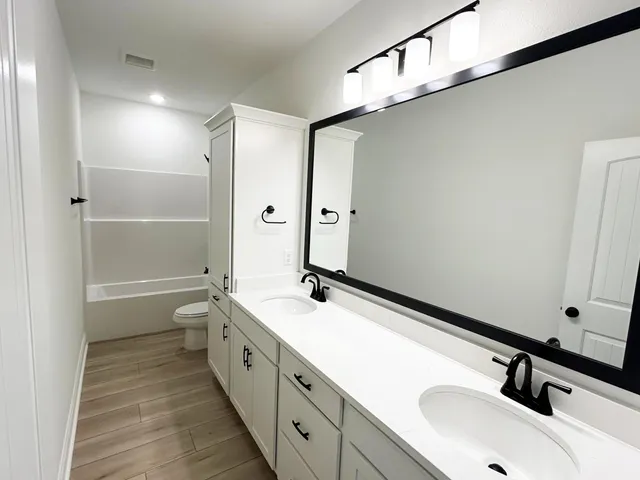 a bathroom with a double vanity sink and mirror