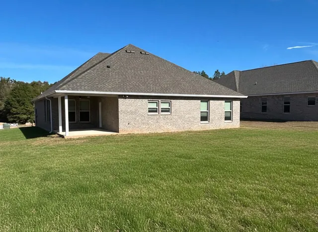a front view of a house with yard and green space