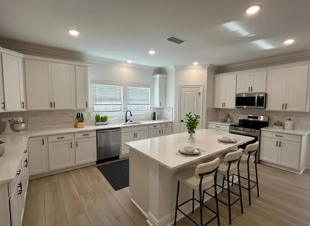 a kitchen with sink a microwave and cabinets