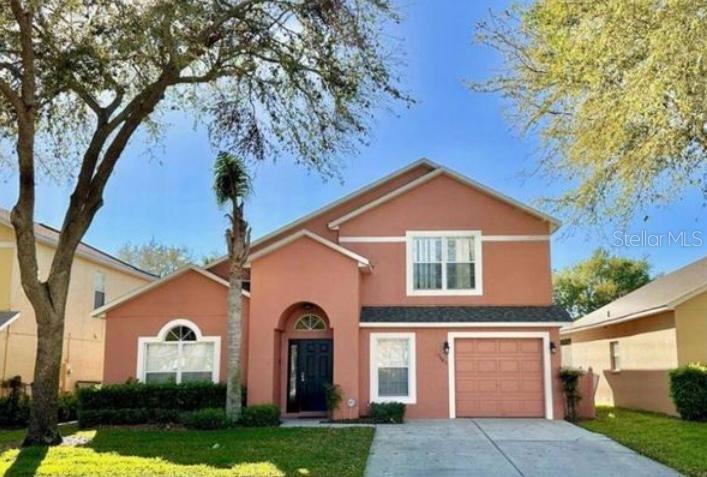 a view of a brick house with a large windows and a large tree