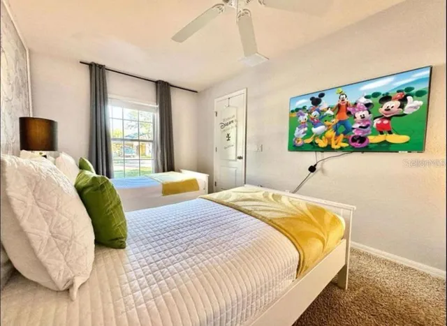 a bedroom with a bed a painting on the wall and a window