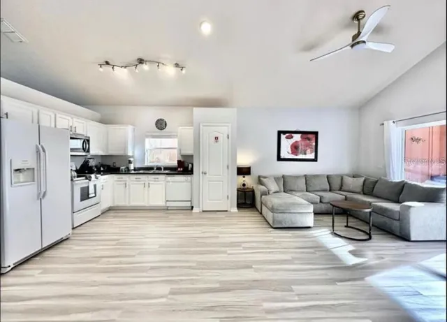 a living room with furniture and kitchen view